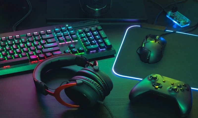 A gaming headphone along with other gaming accessories on a table